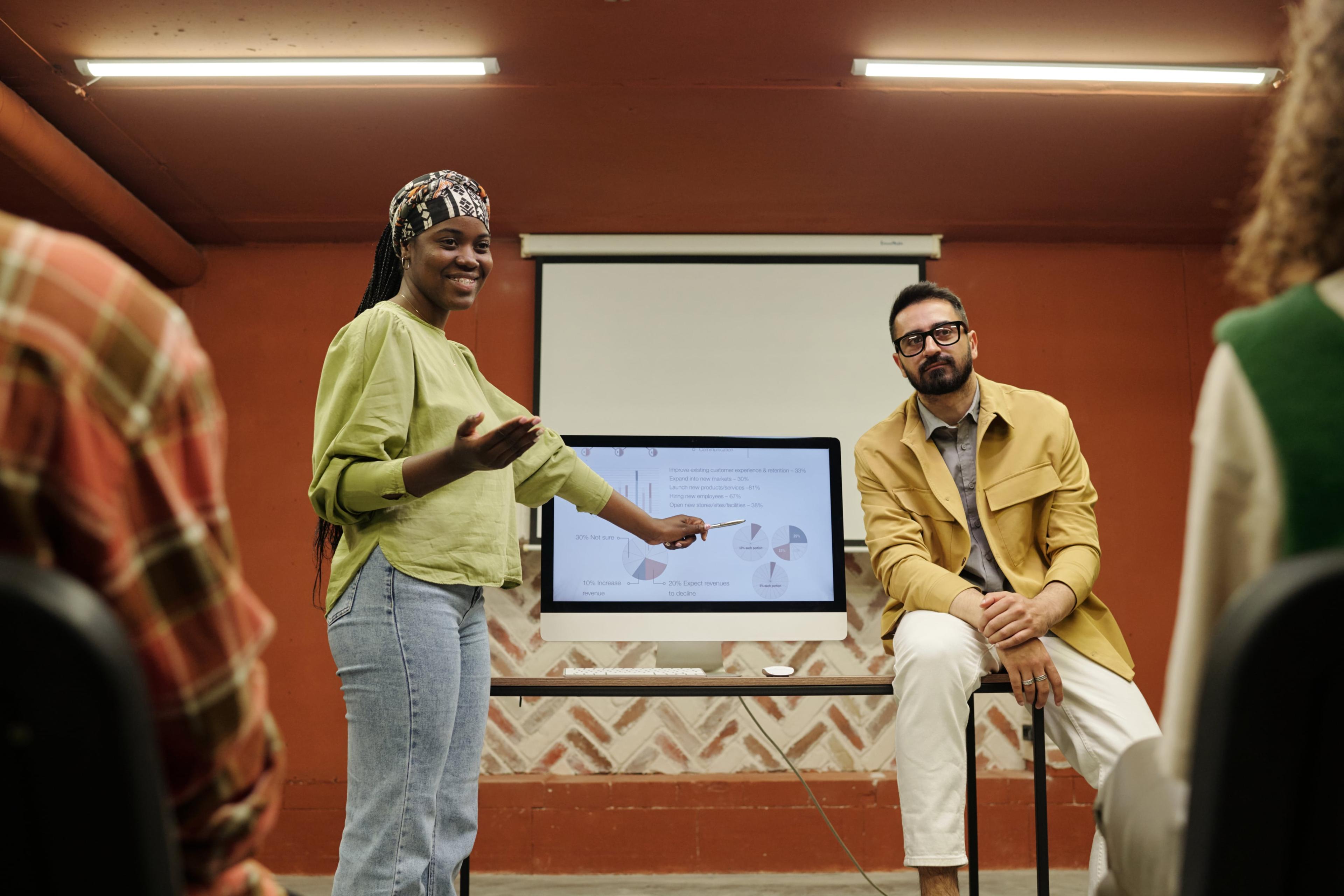 happy-young-african-american-speaker-pointing-computer-screen-with-diagrams