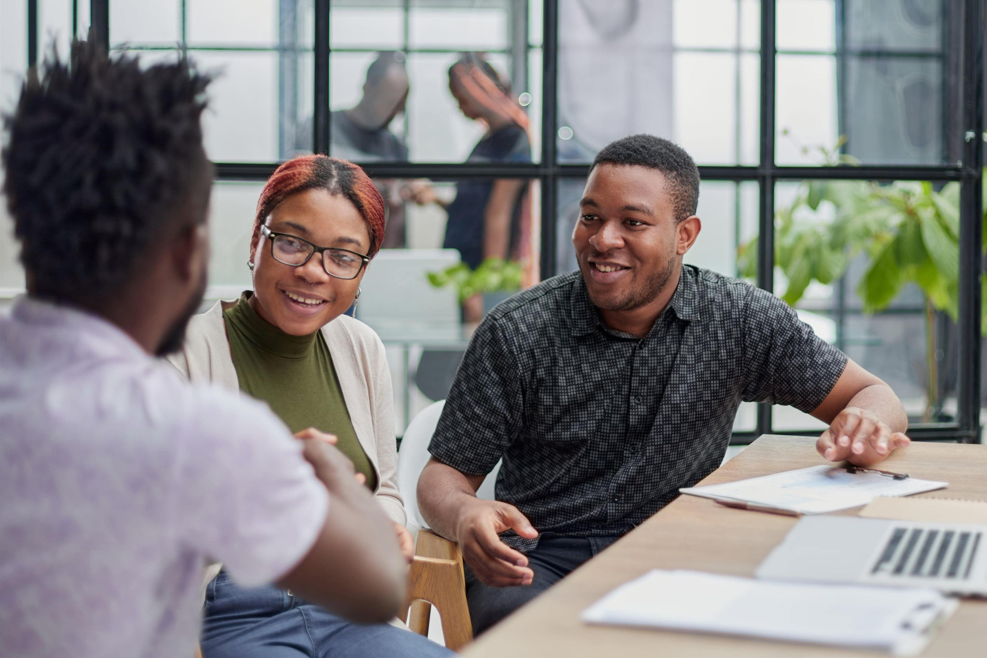 happy-young-african-american-speaker-pointing-computer-screen-with-diagrams